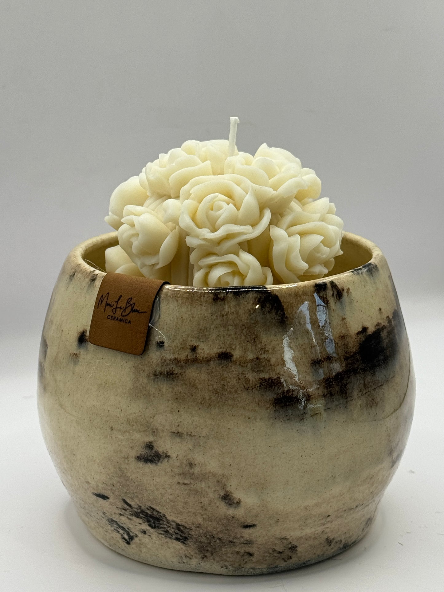 Tazón blanco con ramo de flores en vela de soya