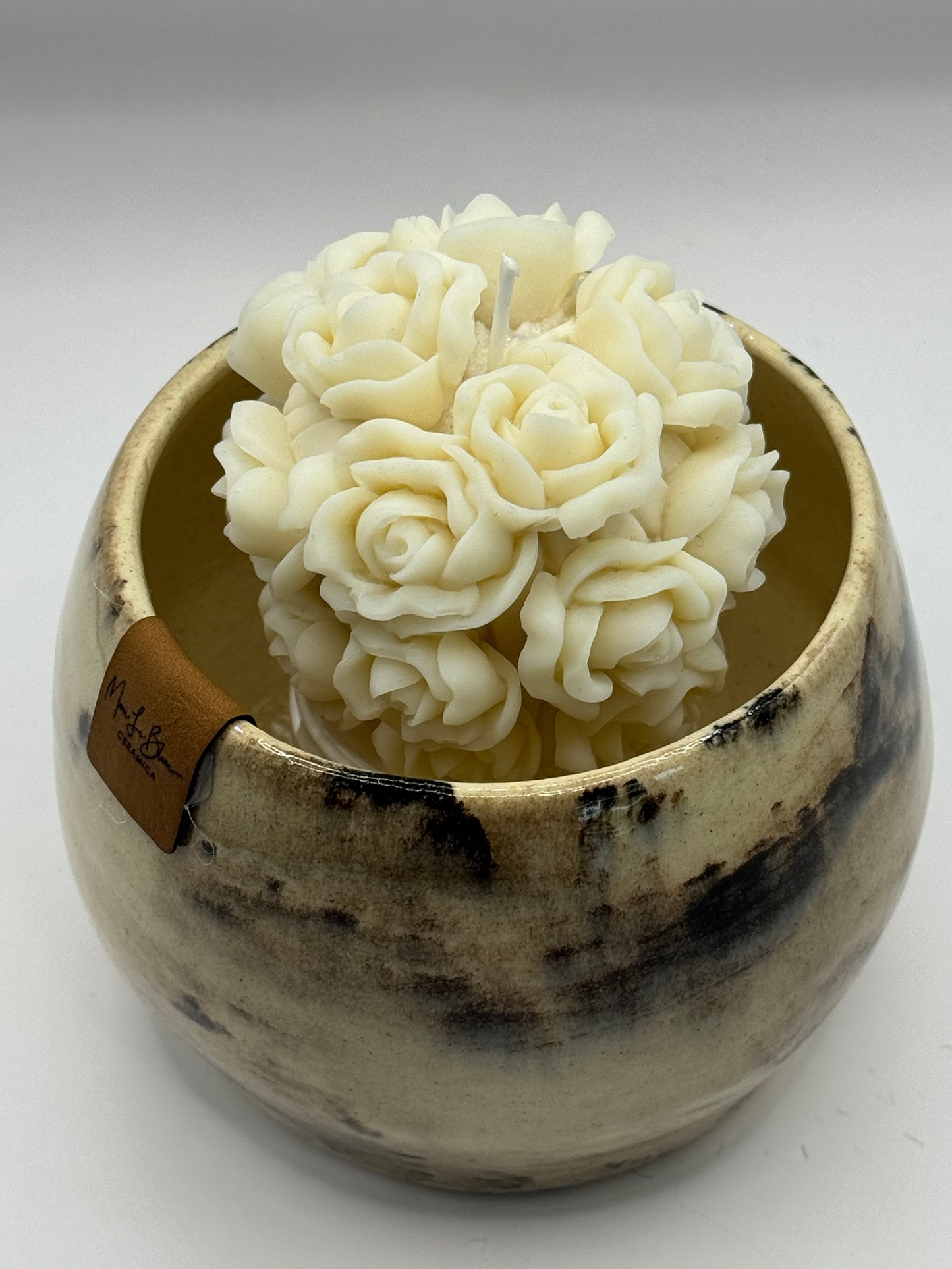 Tazón blanco con ramo de flores en vela de soya